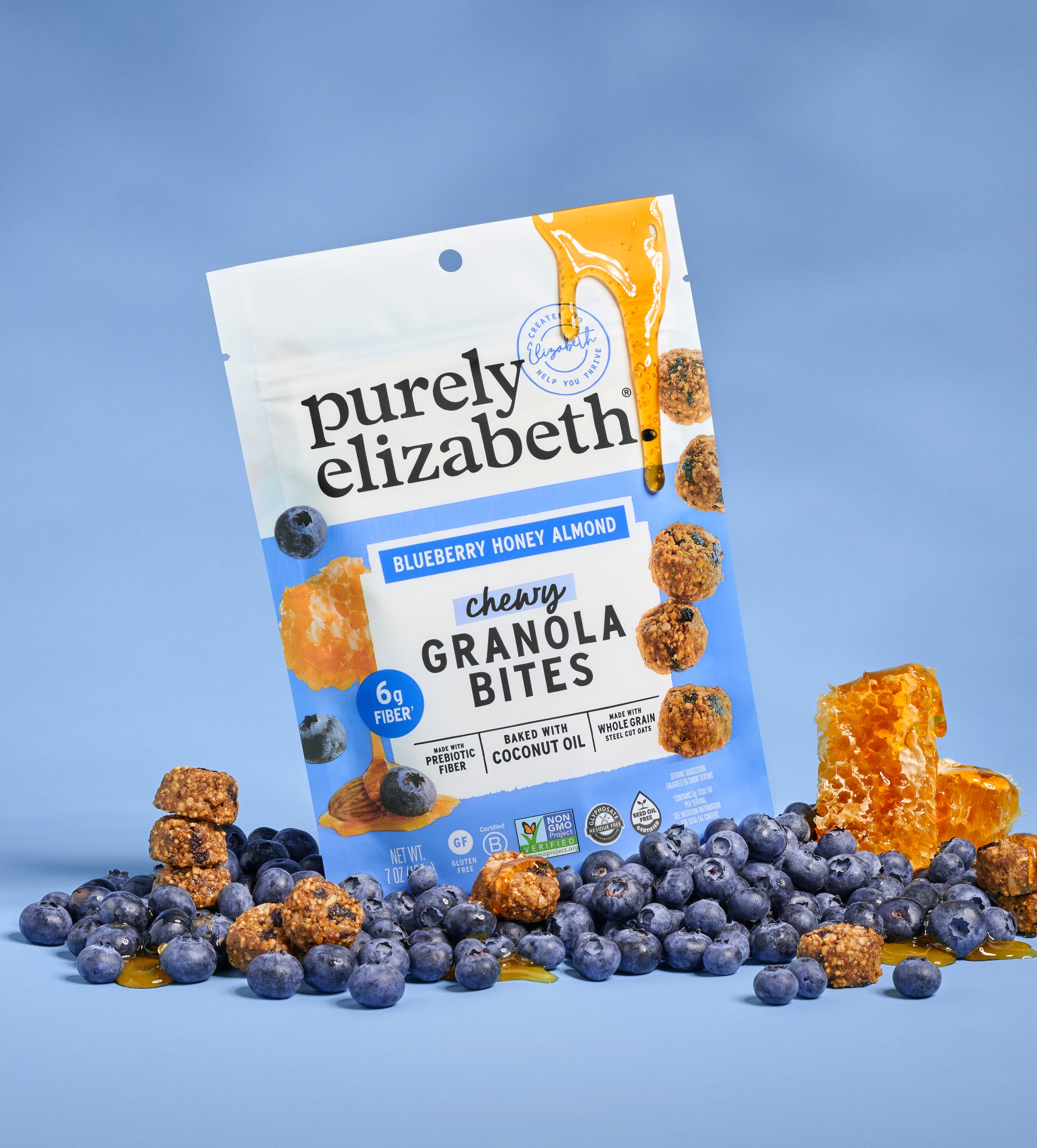 Granola Bites Variety Pack four pack packaging with blueberry accents and honey drizzle on a blue backdrop