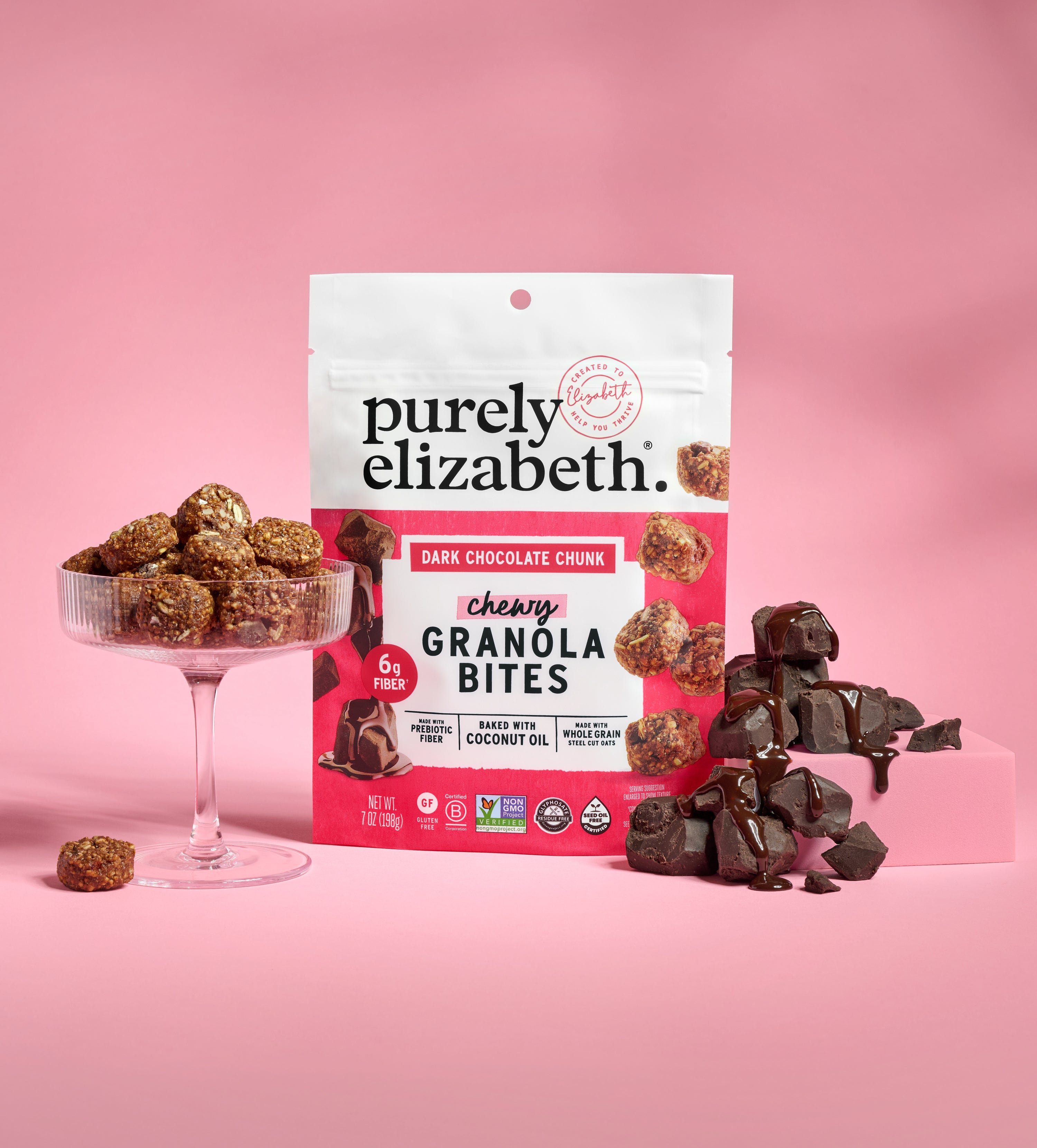 Purely Elizabeth granola bites bag with branding on a pink backdrop and a bowl of bites nearby