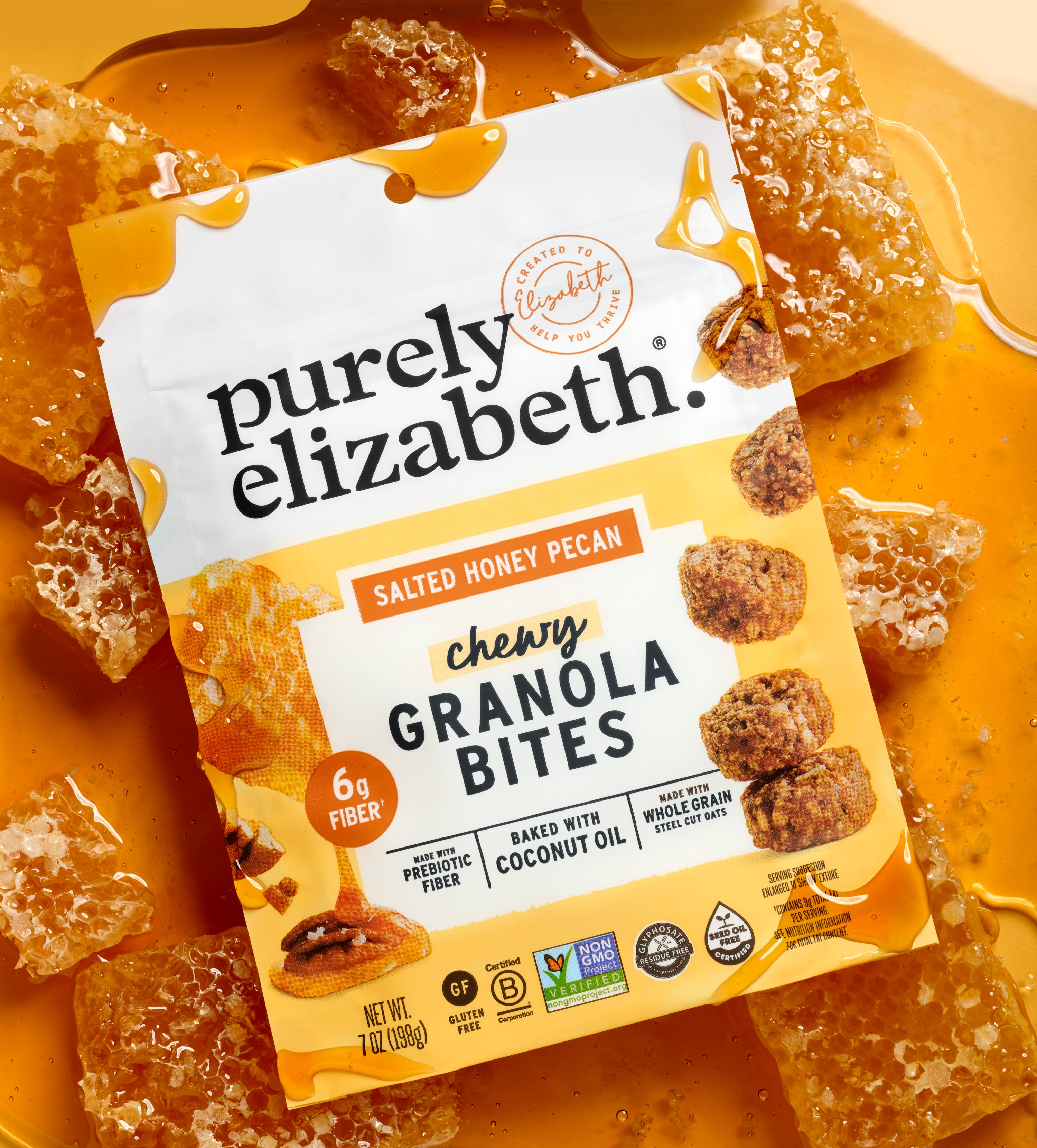 Salted Honey Pecan Granola Bites bag tilted amid honey and crunchy granola clusters on a warm orange backdrop